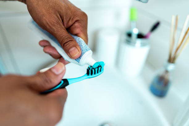 istock Close-up of a man putting toothpaste on toothbrush 2150338420