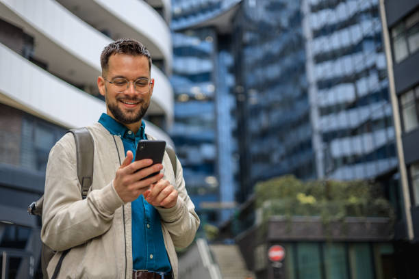 Checking his smart phone while in the city