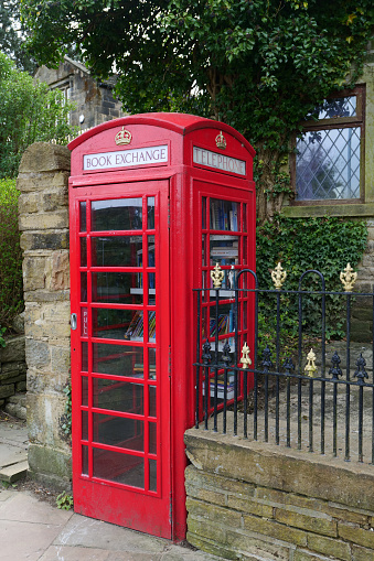 Haworth, UK 04 25 2024 Red K6 telephone box repurposed as a community book exchange library.