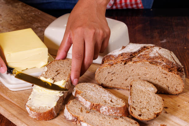 istock Rustic Home Baking: Fresh Rye Bread with Butter on Wooden Board 2150342922