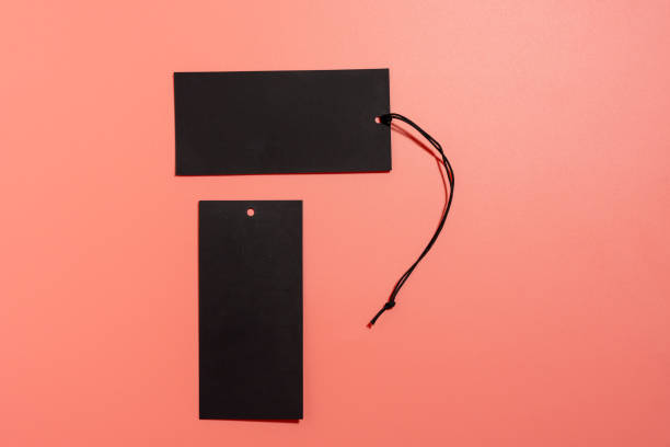 Black label with black cord with space for writing on a pink background. Black label on a pink background.