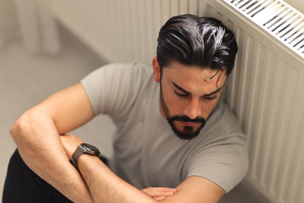 istock Man sitting alone at home looking sad and distraught 2150344388