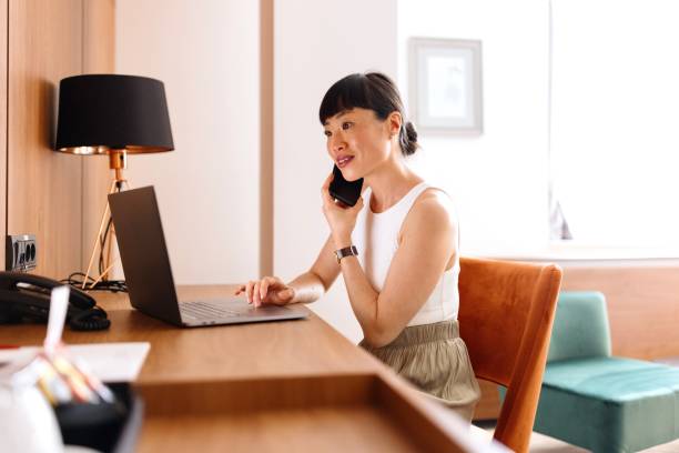 istock Productive woman working on a laptop from a hotel room 2150345462