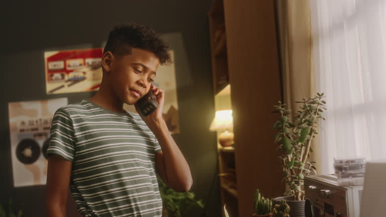 Young Boy Calling Parent Using Old Corded Phone at Home in 90s