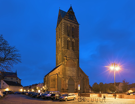 Wismar, Germany - October 21, 2016: Extant tower of St. Mary's Church (Marienkirche) in dusk. The church was built around 1260-70. It was severely damaged by air bombs in April 1945, and then was demolished up to the tower in 1960.