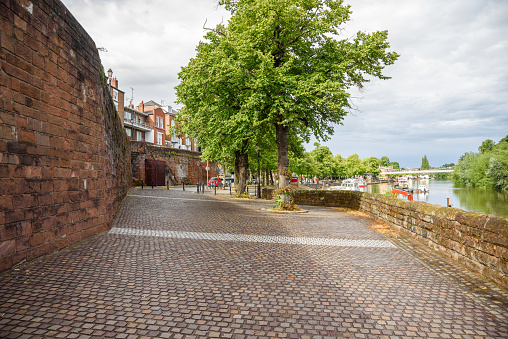 Riverbank park along old city walls in Chester on a cloudy summer day. England, UK.