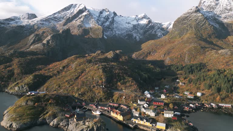 Nusfjord fishing village in norway with autumn colors and snowy peaks, aerial view