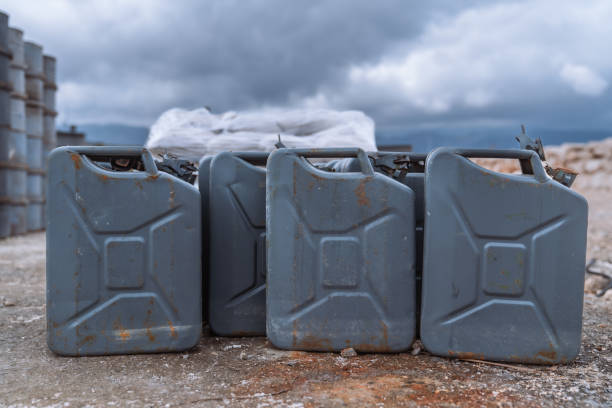 Close-up of two black metal petrol cans with tube standing at border of road at Swiss Airport Zürich Kloten on a sunny late winter day. Photo taken March 6th, 2025, Zurich Kloten, Switzerland.