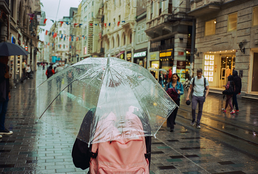 Unrecognisable with transparent umbrella walking on the streets of Istanbul during the rain. SHot on camera film