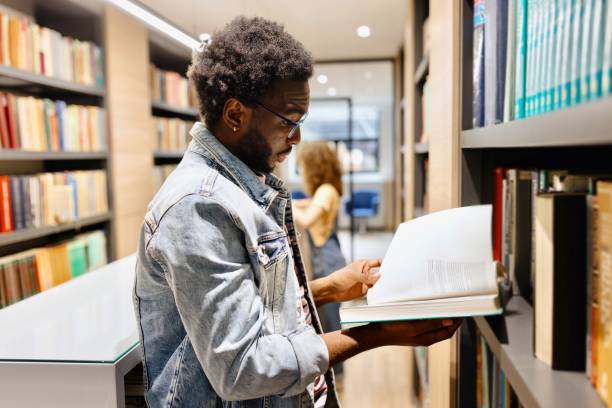 istock Close-up of a young black student looking for a book at the library 2150353912