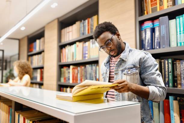 istock Productive young people reading books at the library 2150353923