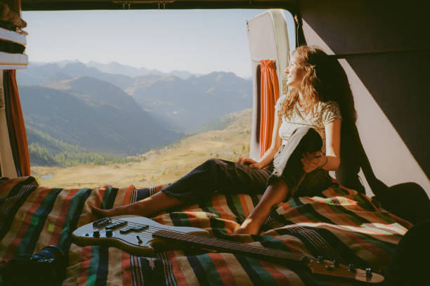 istock Woman with guitar in camper van in mountains 2150354903