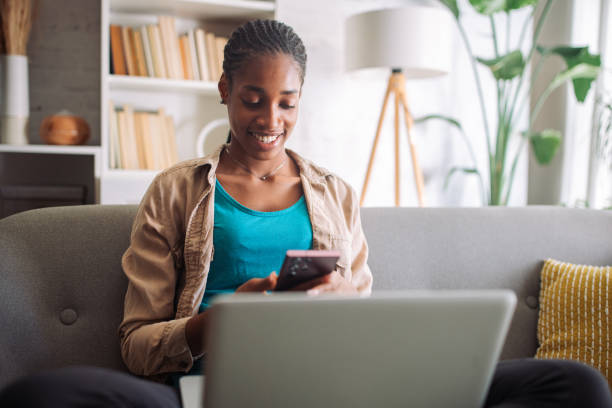 istock Woman browsing phone with laptop open 2150355595
