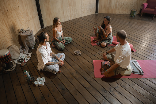 Group of people gathered in a cocoa and kundalini ceremony inside a palapa.