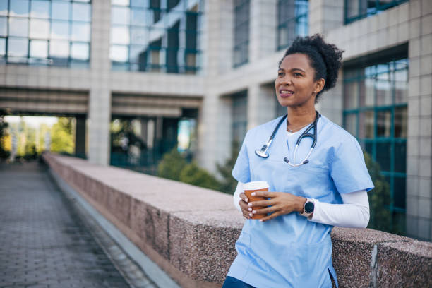 istock Female doctor standing outdoors and holding the coffee cup. 2150358310