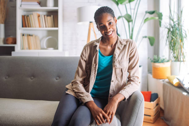 istock Smiling woman sitting on sofa 2150358315