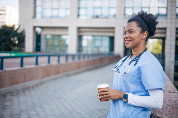 istock Female doctor standing outdoors and holding the coffee cup. 2150358391