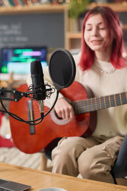 istock Microphone and musician with guitar 2150358484