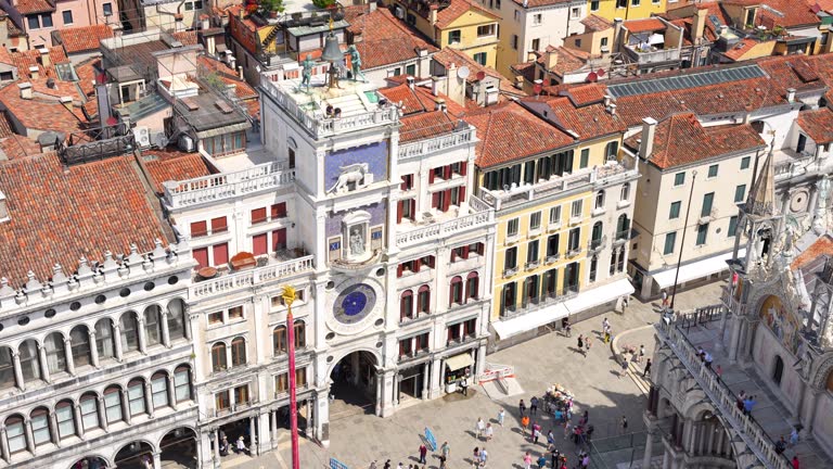 Iconic Torre dell'Orologio in Venice with people walking nearby, view from above