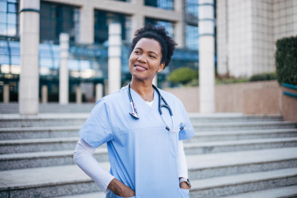 istock Nurse is standing in uniform, with a stethoscope around her neck, looking at the camera and keeping her hands in her pockets. 2150358820