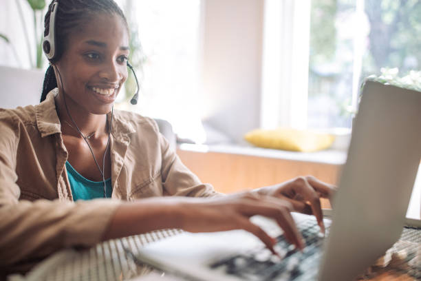 istock Woman typing on laptop with headset on 2150358861