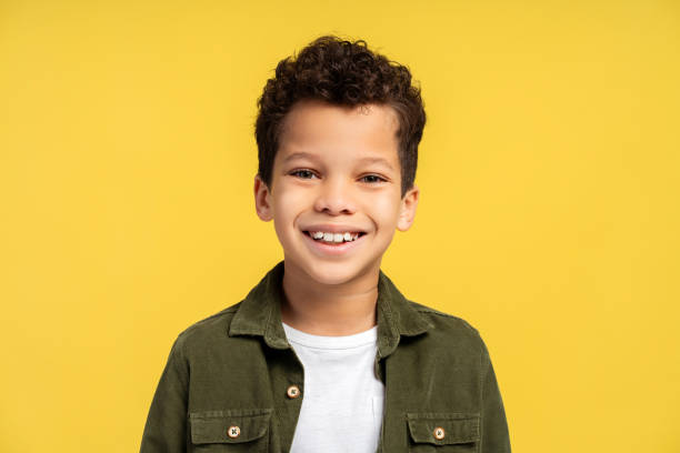 istock Portrait happy African American boy looking at camera while posing, isolated on yellow background 2150361483