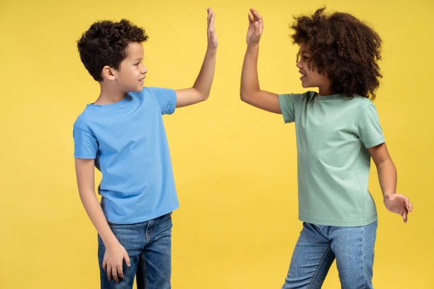 istock Two small kids giving high five and smiling to each other while posing in studio. Friendship concept 2150361522