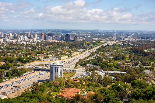 View over the busy 405 highway and Century City on a partly cloudy day seen from the Santa Monica Mountains in Los Angeles