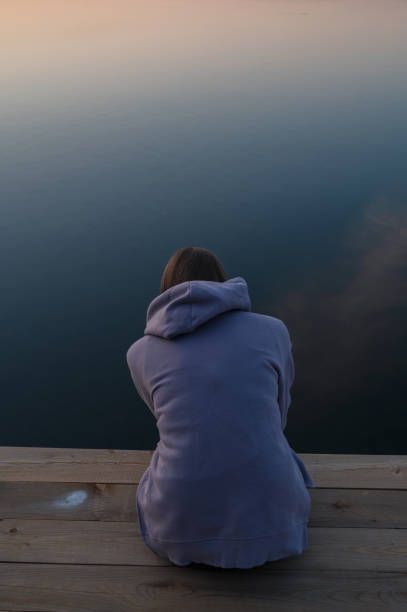 istock Woman sitting on the pier 2150364169