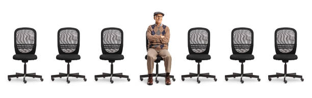 istock Elderly man sitting in an office chair with other empty chairs around 2150364784