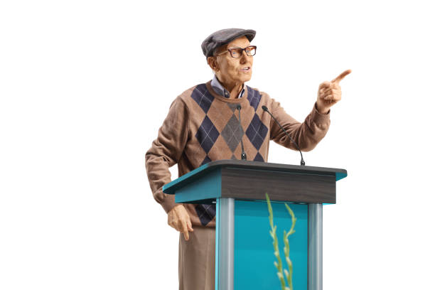 istock Mature male speaker talking on a pedestal and gesturing with finger 2150364813