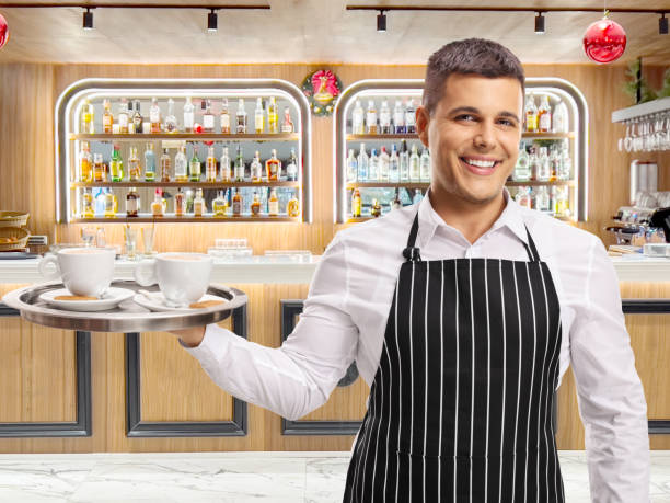 Waiter with coffee on a tray at a hotel bar
