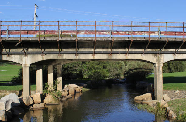 Bridge over a tranquil river of water surrounded by greenery at Quart Pot Creek in Stanthorpe, Queensland, Australia