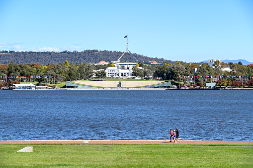 Canberra, Australia, 24 April 2024. On a sunny autumn day, people are running around the lake in Canberra