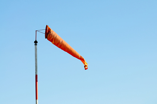 An Orange Windsock or Windvane Against the Blue Sky
