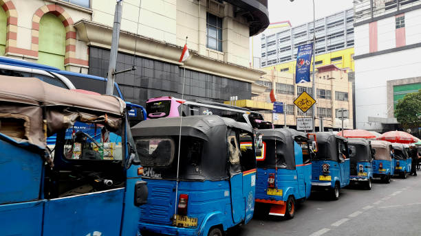 Jakarta Bajaj Three Wheelers Jakarta, Indonesia - Sept 23, 2023: A back view of a row of blue Bajaj vehicles, three-wheelers, around Tanah Abang Market. bajaj public transportation stock pictures, royalty-free photos & images