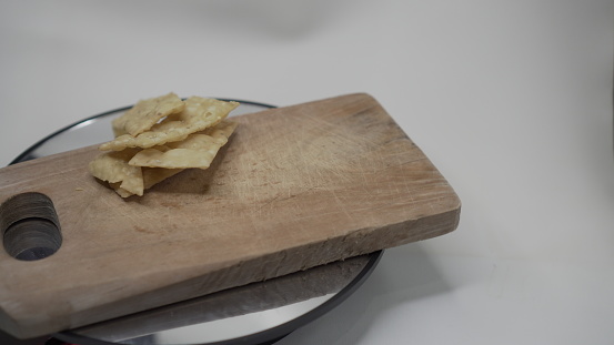 What is usually called here is a snack of onion chips which is usually eaten together with chicken noodles or meatballs. These foods with brown onion chips and soup are placed on a rotating wooden cutting board.