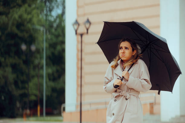 istock Woman Holding an Umbrella feeling Cold During Spring Season 2150374065