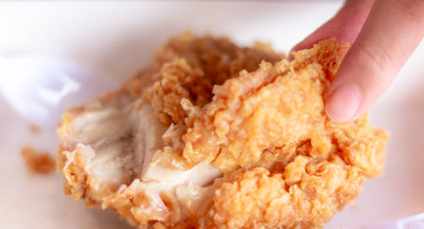 istock Woman eating fried chicken blurred background 2150378245