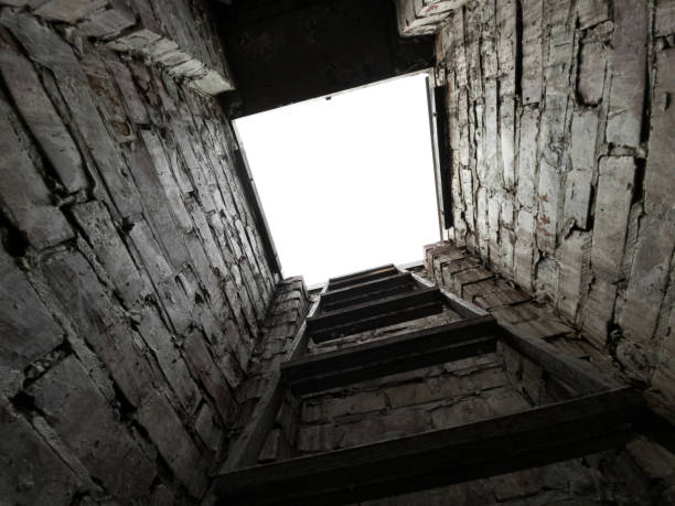 istock Exit from the basement by ladder to the surface. View from the brick basement up from the first face. Manhole. 2150378295