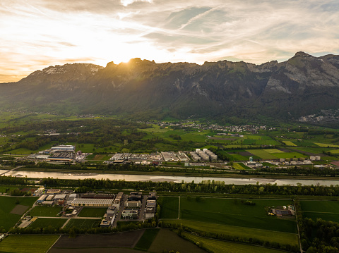 Aerial view of beautiful agricultural land and Ruggell town during springtime in Switzerland surrounded by Alps. St. Gallen Canton.