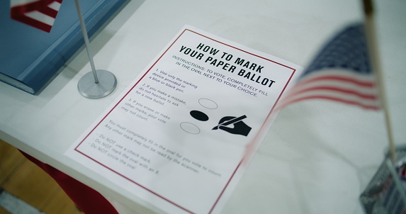 Close up of instruction on how to vote on the paper ballot lying on table at polling place. Elections in the United States of America. Presidential race and election coverage. Civic duty and democracy