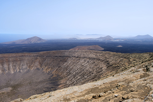 View of the crater of the Caldera Blanca volcano and the island of Lanzarote, Canary Islands.