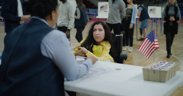 istock Woman with SMA comes and talks with polling officer 2150381145