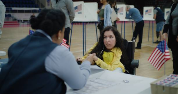 istock Woman with SMA comes and talks with polling officer 2150381672