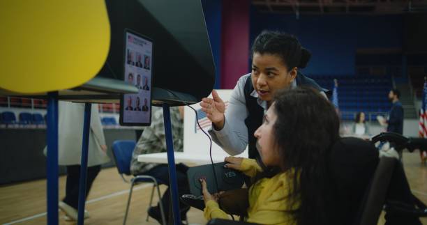 Female US voter with SMA uses remote buttons and votes on tablet