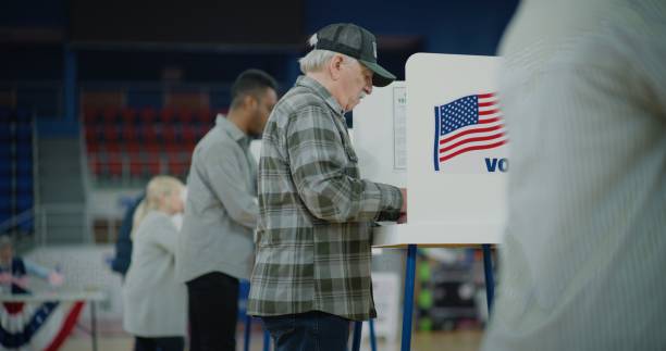 istock Elderly voter with bulletin in hands comes to voting booth 2150382070