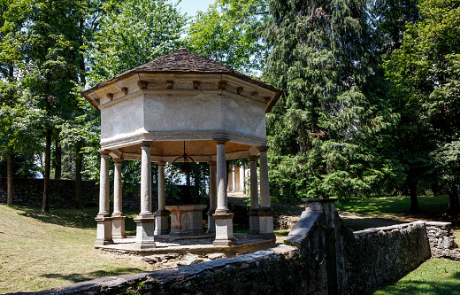 Empty gazebo by retaining wall surrounded with lush green trees in park at Sacro Monte di Orta at Italy during sunny day