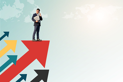 Professional businessman standing on red arrow symbolizing growth and success. Financial growth concept.