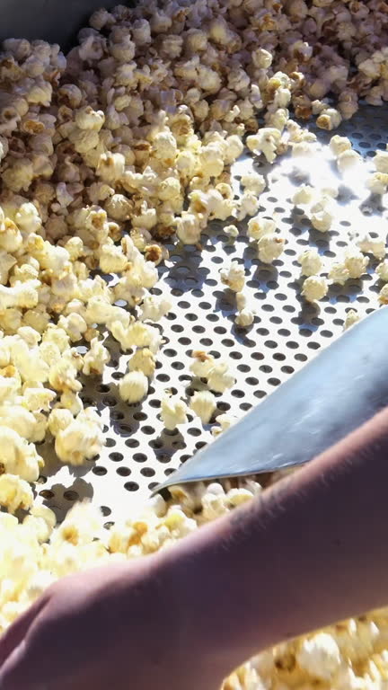 Super Slow Motion Shot of Fresh Fluffy Popcorn Flying Towards the Camera. Vertical video